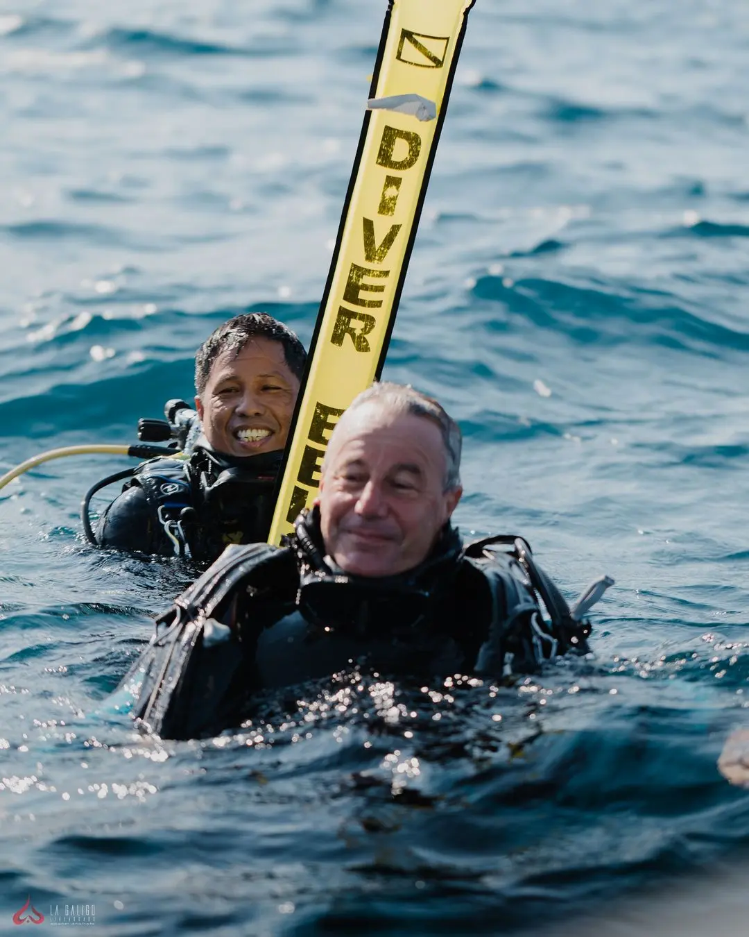 scuba divers with buoy on surface