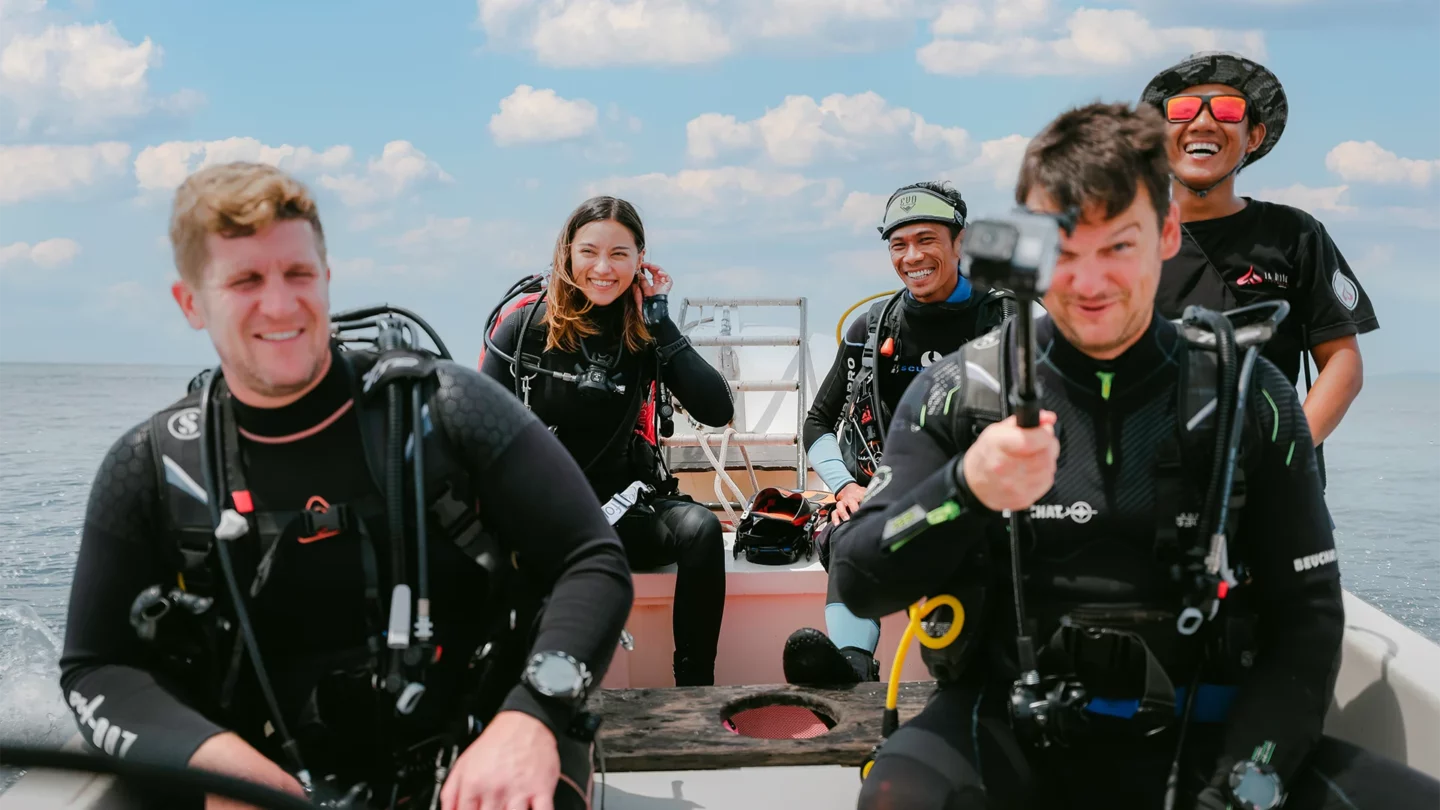 Scuba divers in a happy mood to dive from a boat