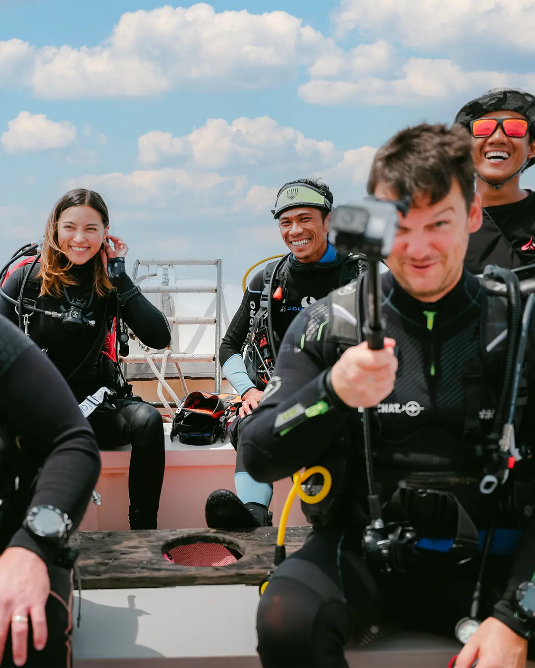 smiling fun scuba divers on speedboat