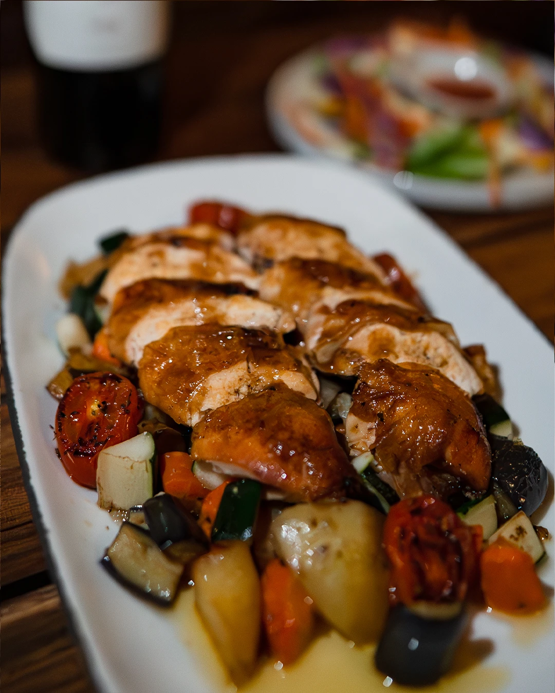 Grilled chicken breast with roasted vegetables and rich pan sauce.