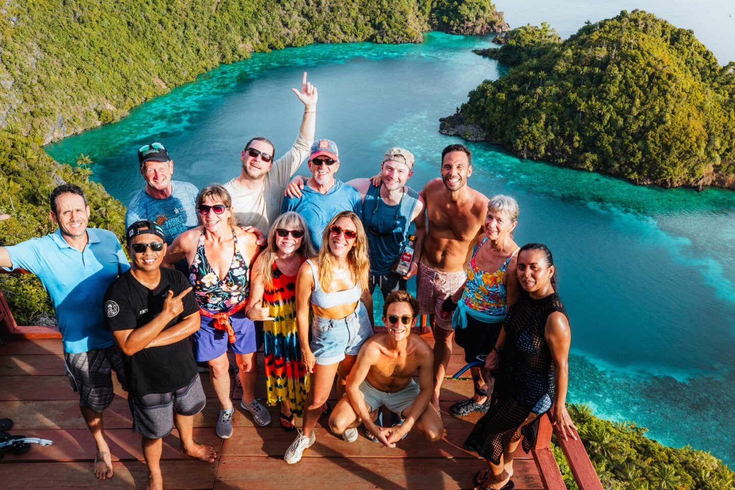 Lagaligo Liveabooard Guest taking a photo from the Love Lagoon viewpoint in Misool, Raja Ampat, overlooking the heart-shaped turquoise lagoon surrounded by limestone karst cliffs