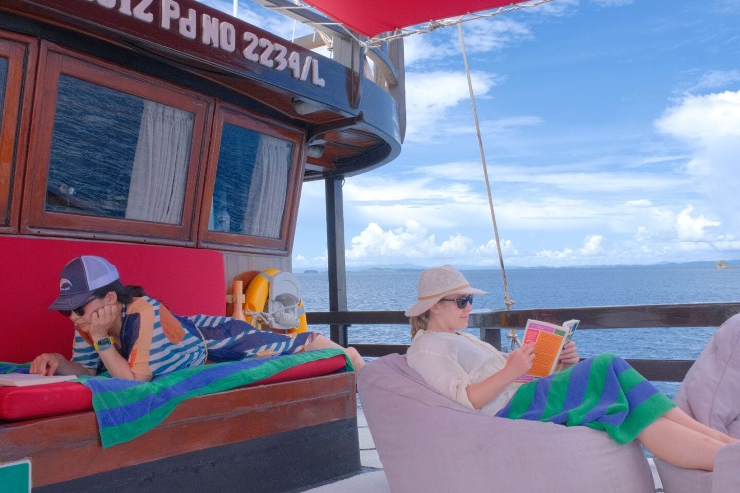 Guests enjoying a relaxed surface interval on a liveaboard, overlooking open ocean waters.