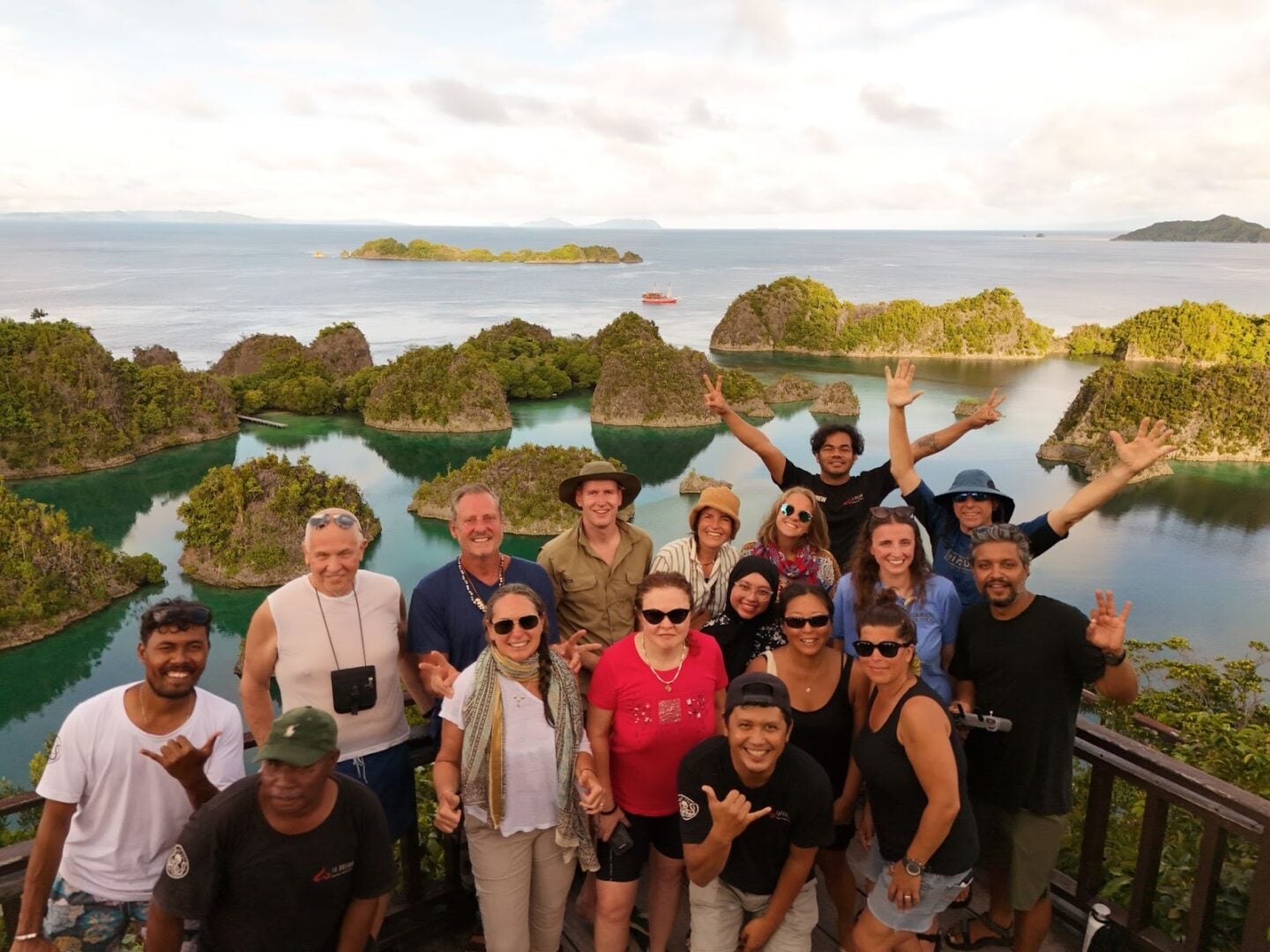Guests aboard La Galigo liveaboard enjoying the panoramic Piaynemo viewpoint in Raja Ampat, overlooking turquoise lagoons and limestone karst islands during a liveaboard journey